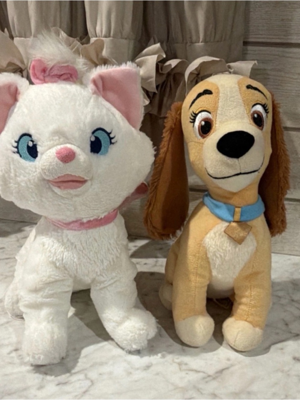 Marie from "The Aristocats" and Lady. Both characters are from the Disney brand